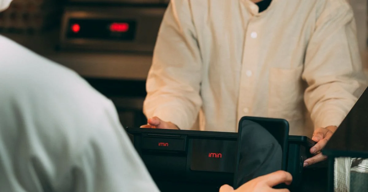 Paiement numérique avec un smartphone à un terminal de point de vente moderne à l'intérieur.